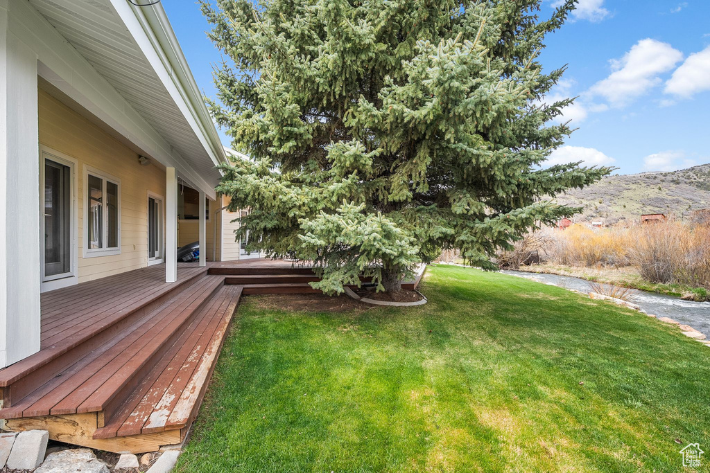 View of yard featuring a deck with mountain view