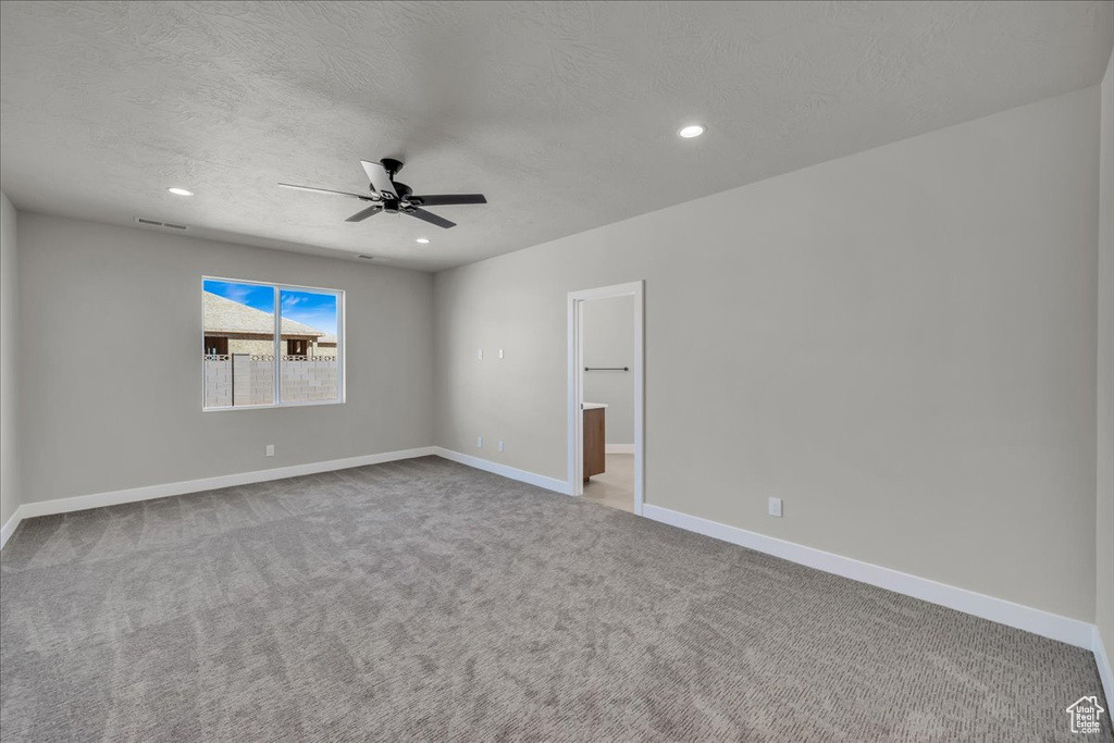 Unfurnished room featuring a ceiling fan, a textured ceiling, visible vents, and carpet floors