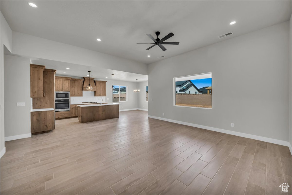 Unfurnished living room featuring baseboards, recessed lighting, light wood-style flooring, and visible vents
