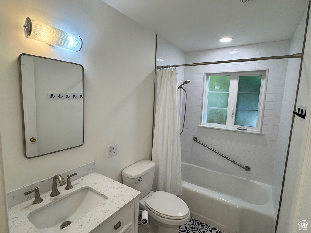Bathroom with vanity, toilet, and shower / bath combo with shower curtain