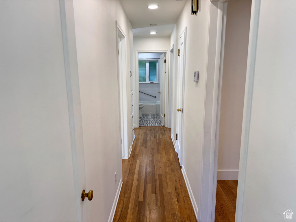 Hallway with recessed lighting, baseboards, and wood finished floors