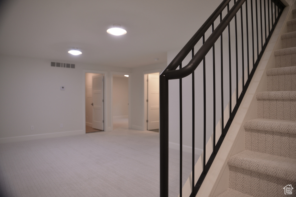 Staircase with carpet, visible vents, and baseboards