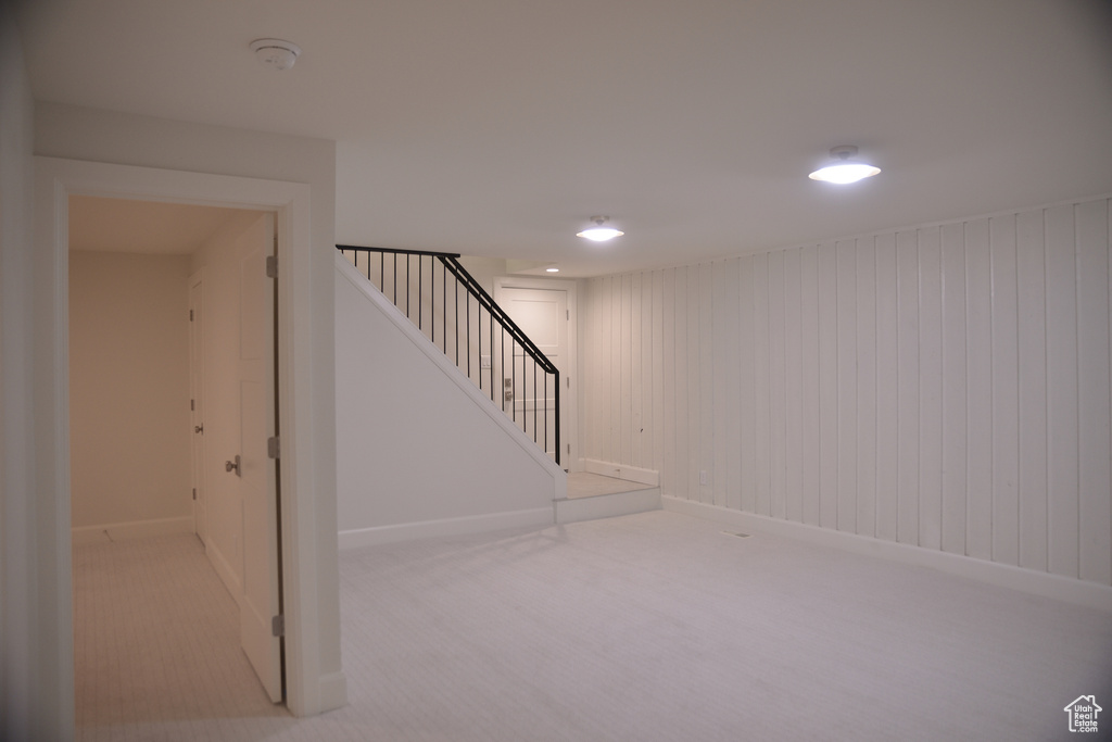 Finished basement with baseboards, stairs, and carpet flooring