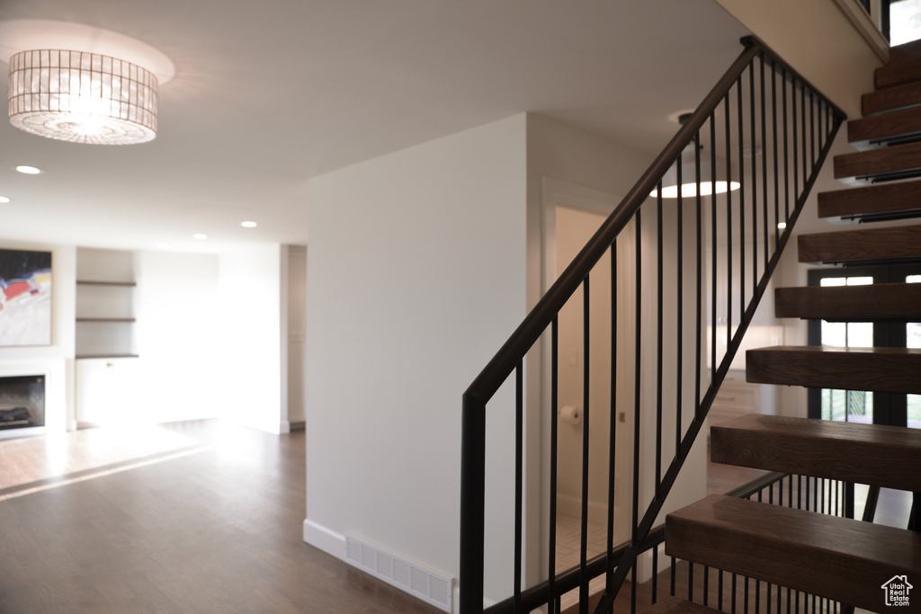 Staircase with visible vents, wood finished floors, baseboards, and recessed lighting
