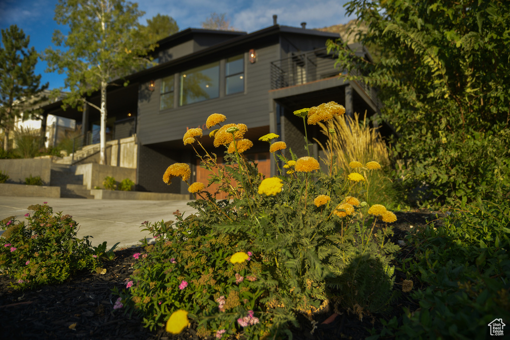 View of side of property featuring a balcony and driveway