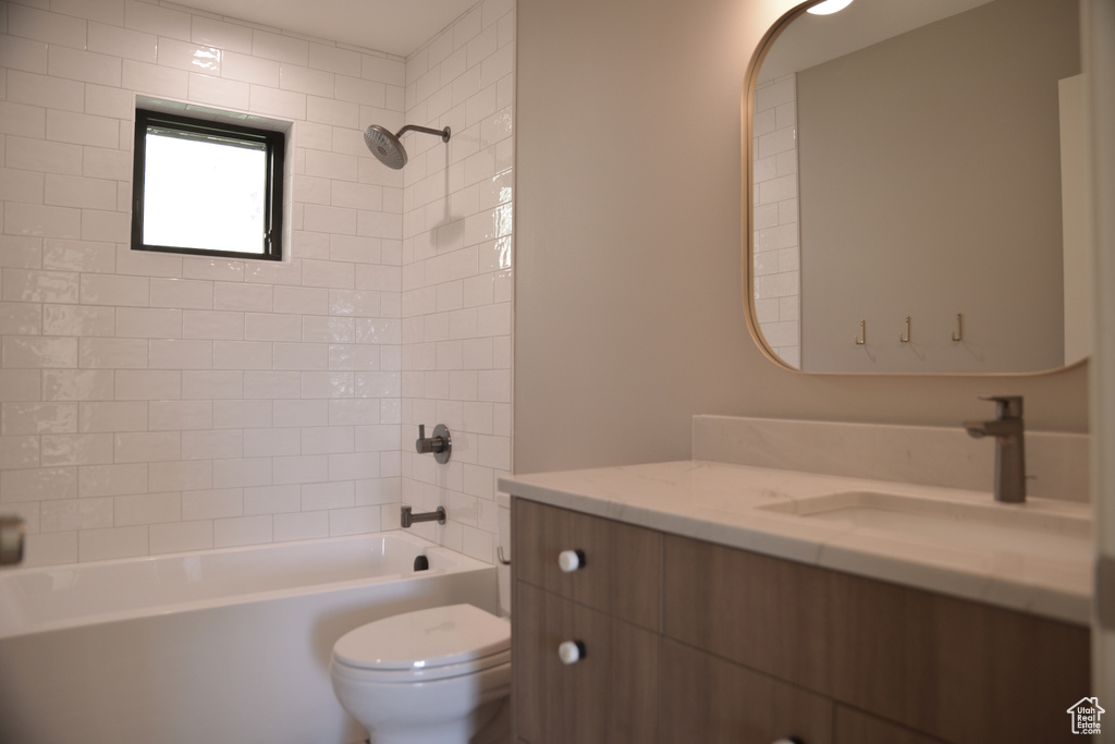 Bathroom featuring vanity, toilet, and shower / washtub combination