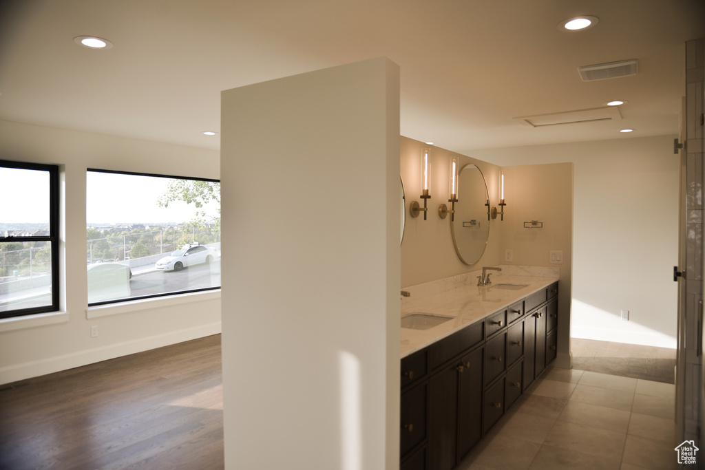 Bathroom featuring recessed lighting, double vanity, visible vents, and a sink