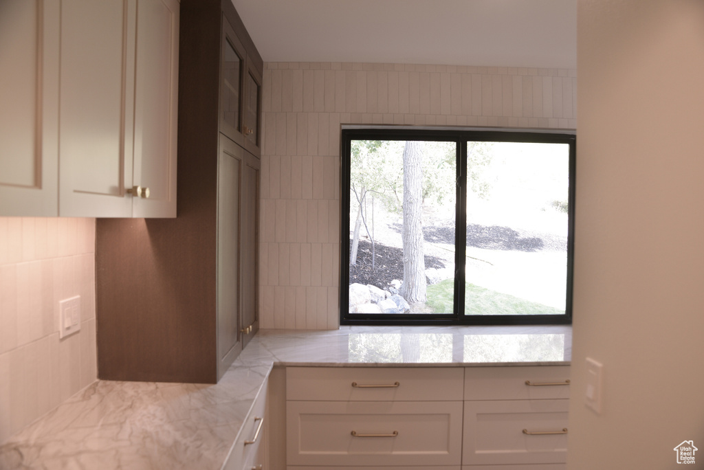 Kitchen with white cabinets and light stone counters