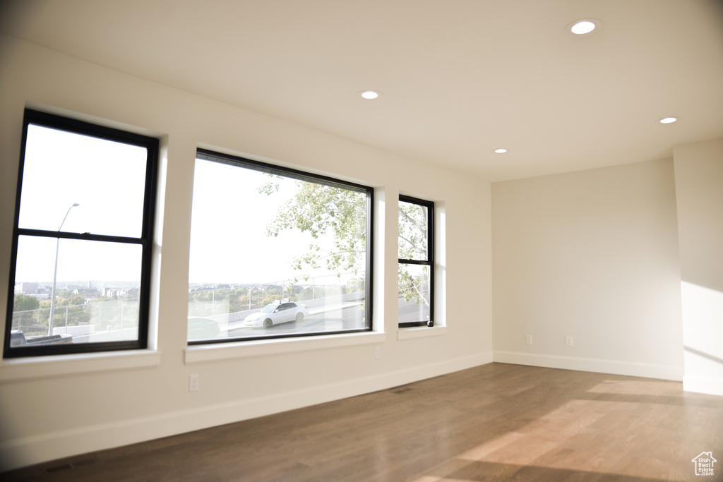 Unfurnished room featuring baseboards, a wealth of natural light, recessed lighting, and wood finished floors