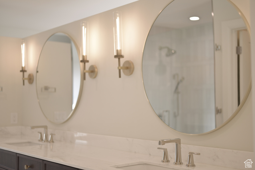 Full bathroom featuring walk in shower, double vanity, and a sink