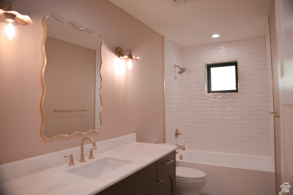 Full bathroom with toilet, washtub / shower combination, vanity, and recessed lighting