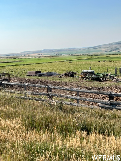View of yard with a rural view and fence
