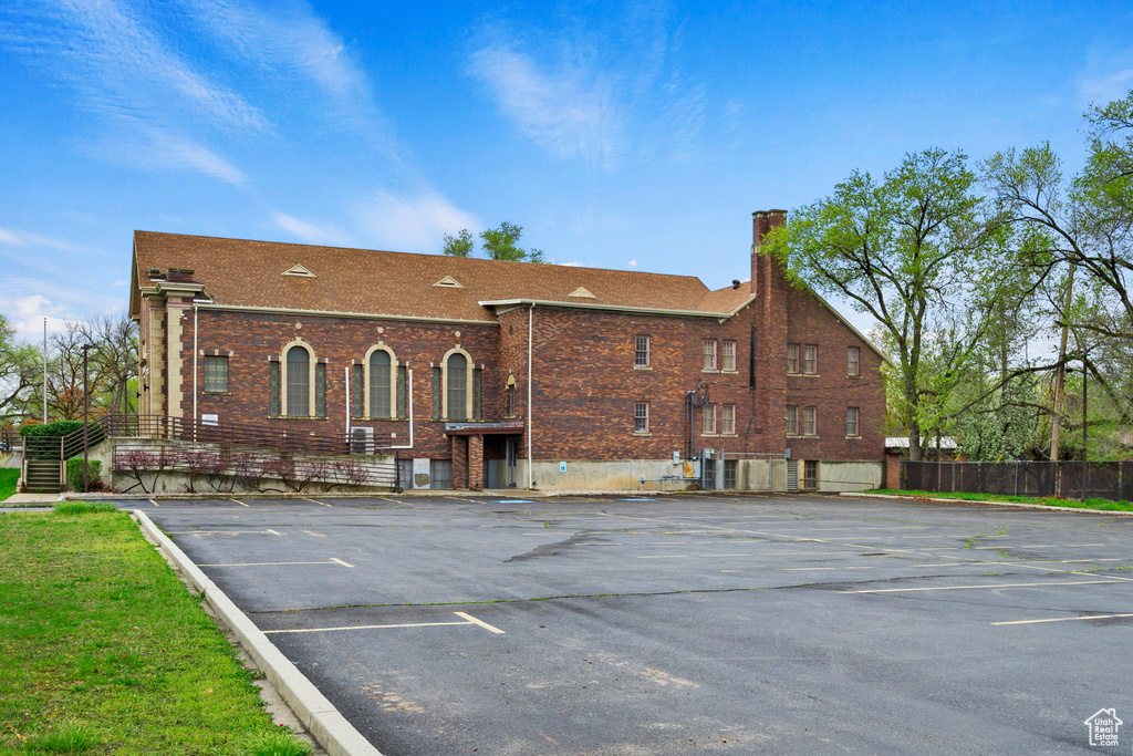 View of property with uncovered parking and fence