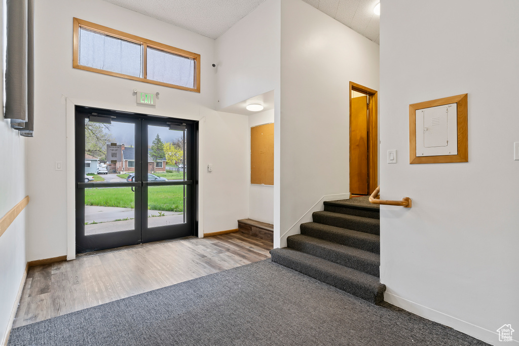 Entryway featuring wood finished floors, baseboards, stairs, and a high ceiling