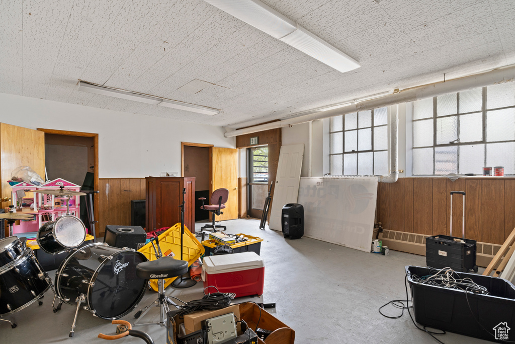 Misc room with wooden walls and concrete floors