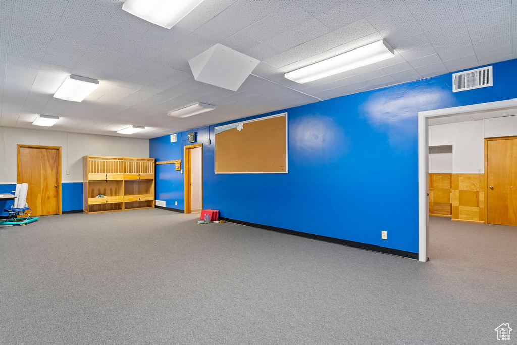 Interior space with carpet flooring, visible vents, and baseboards