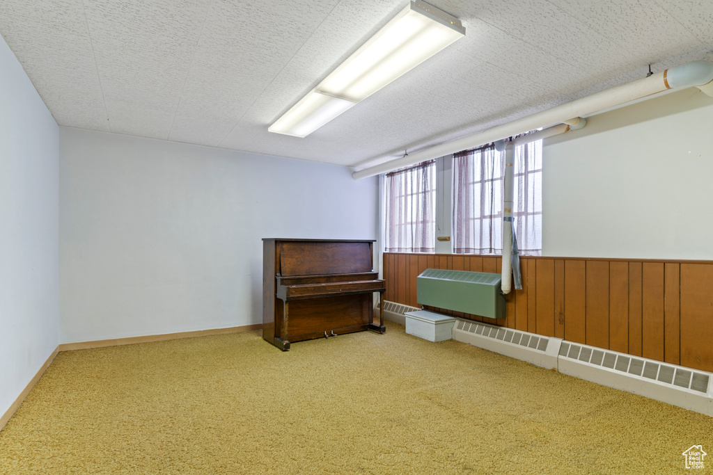 Carpeted empty room featuring wooden walls