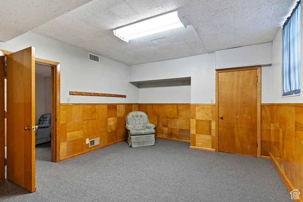 Unfurnished room with visible vents, a wainscoted wall, and carpet flooring