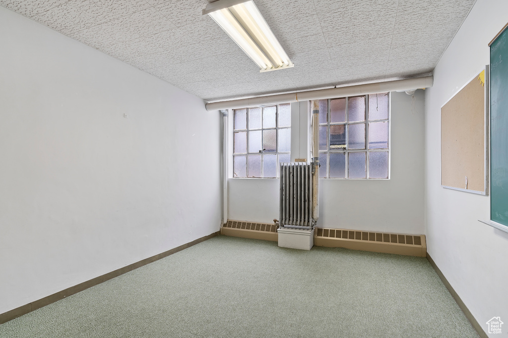 Carpeted empty room featuring visible vents