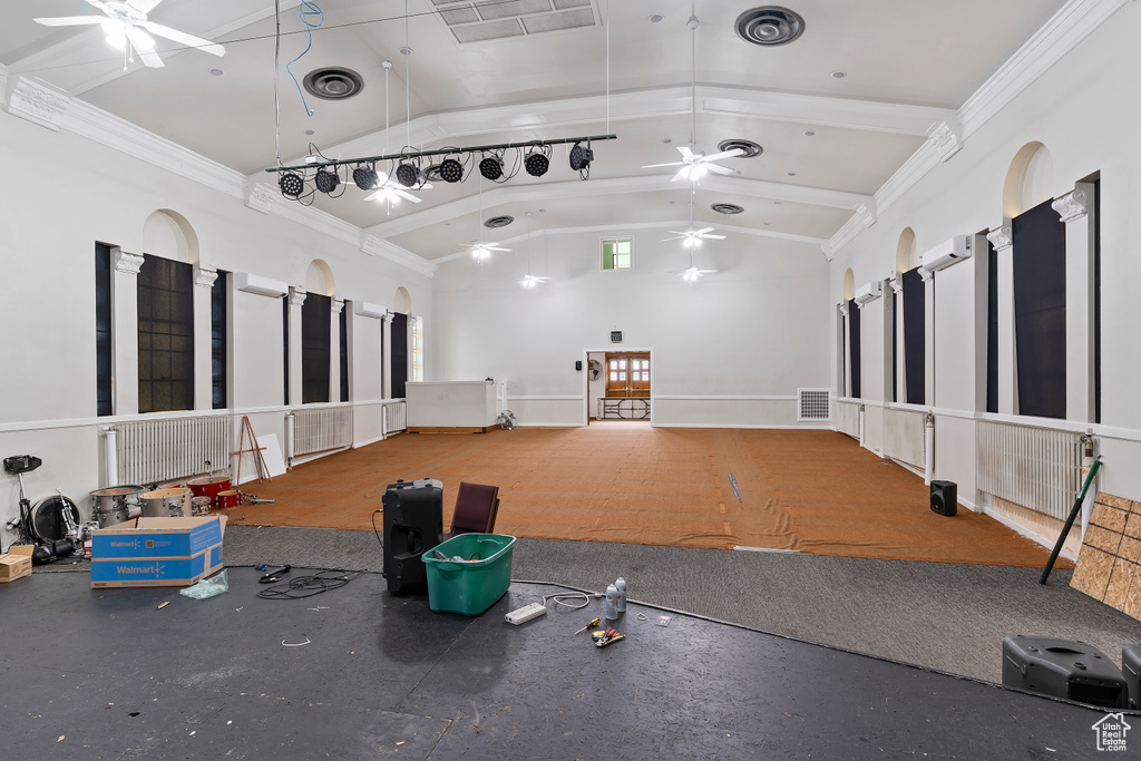Workout area featuring visible vents, ceiling fan, crown molding, and vaulted ceiling