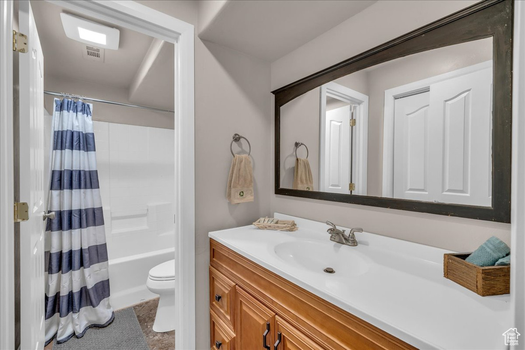 Bathroom with toilet, visible vents, vanity, and shower / bathtub combination with curtain