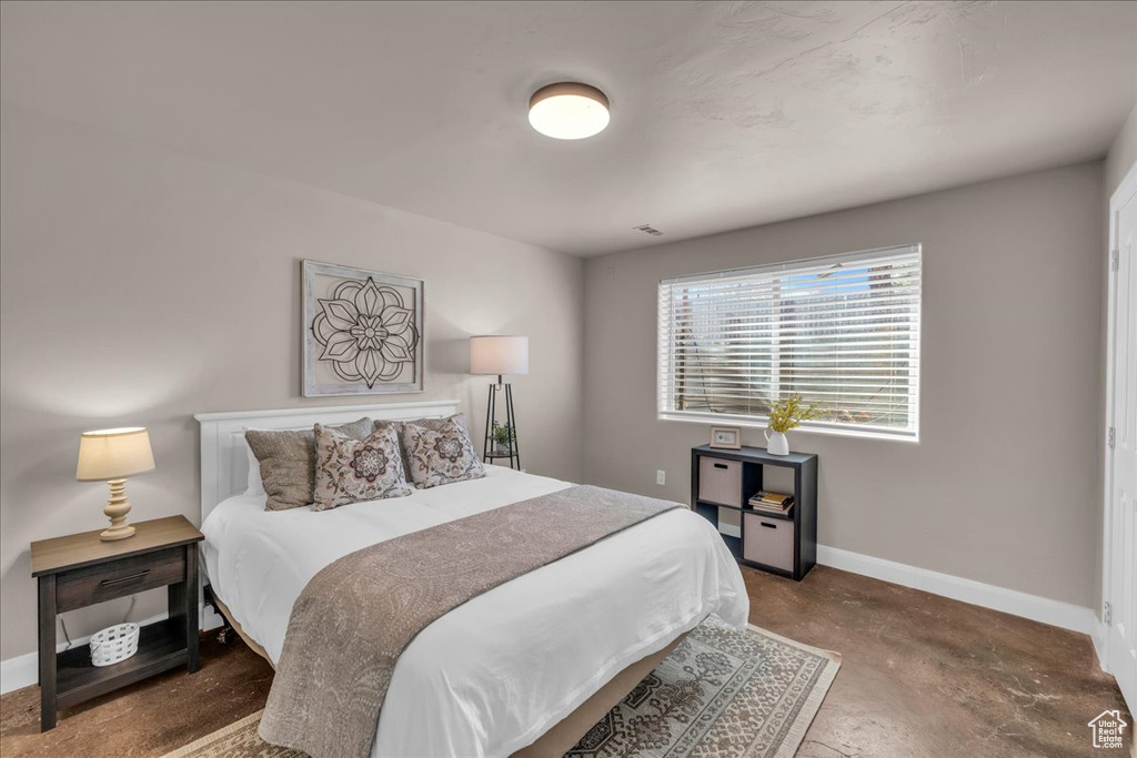 Bedroom featuring baseboards and concrete floors
