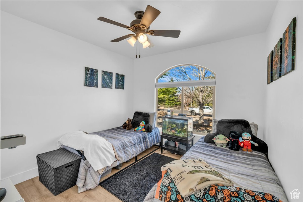Bedroom featuring baseboards, a ceiling fan, and wood finished floors