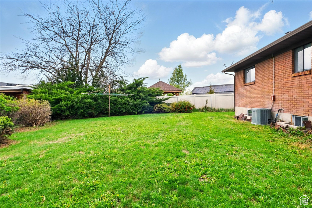 View of yard featuring fence and central AC