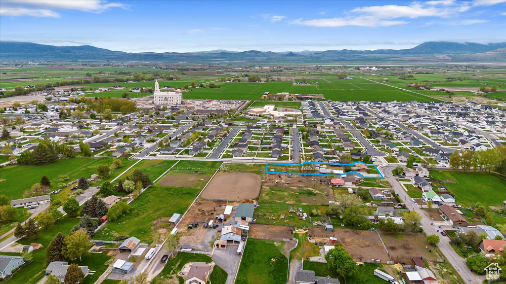 Aerial view of property and surrounding area featuring a mountainous background