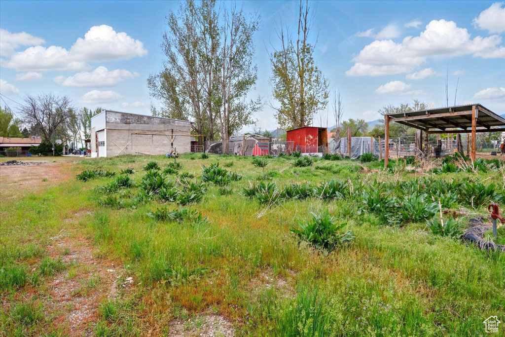 View of yard featuring an outdoor structure and fence