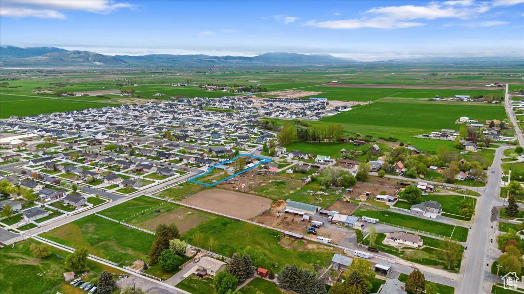 Aerial view of property and surrounding area featuring a mountainous background