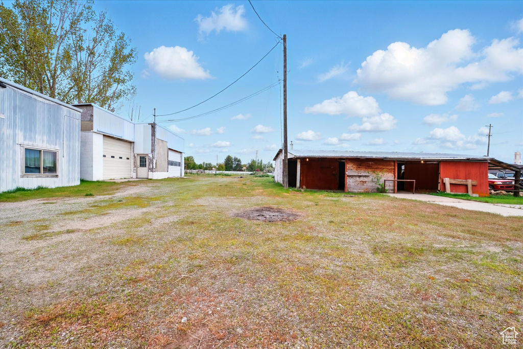 View of yard featuring a pole building and an outdoor structure