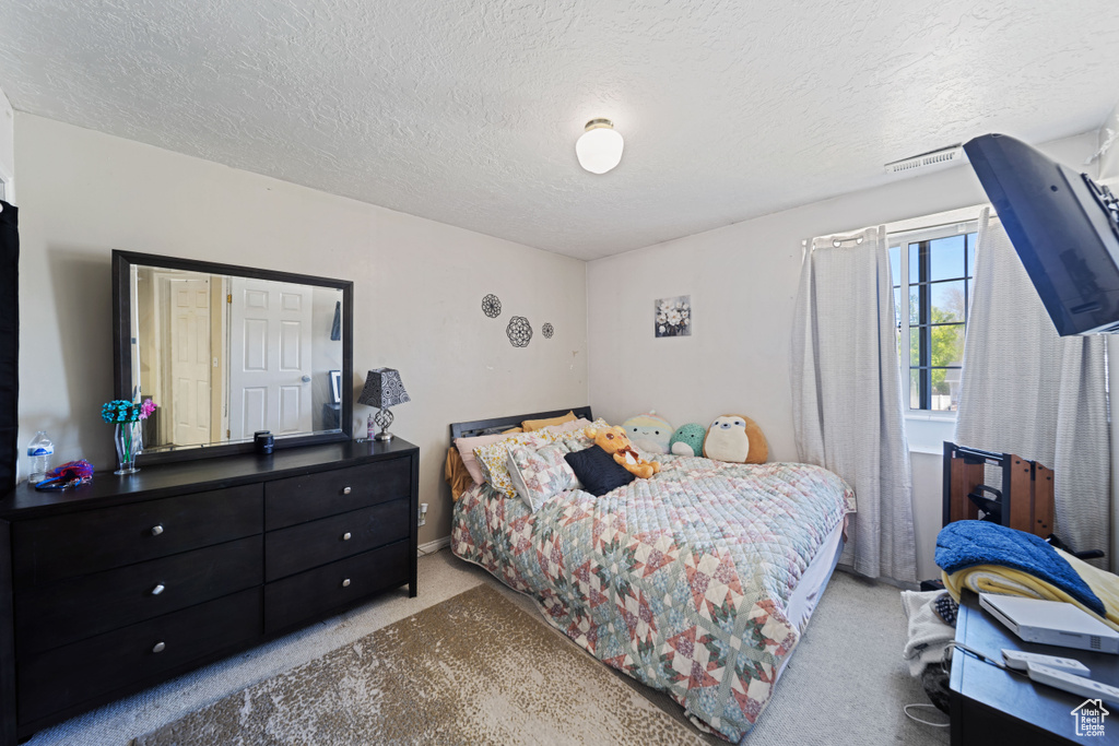 Carpeted bedroom with a textured ceiling