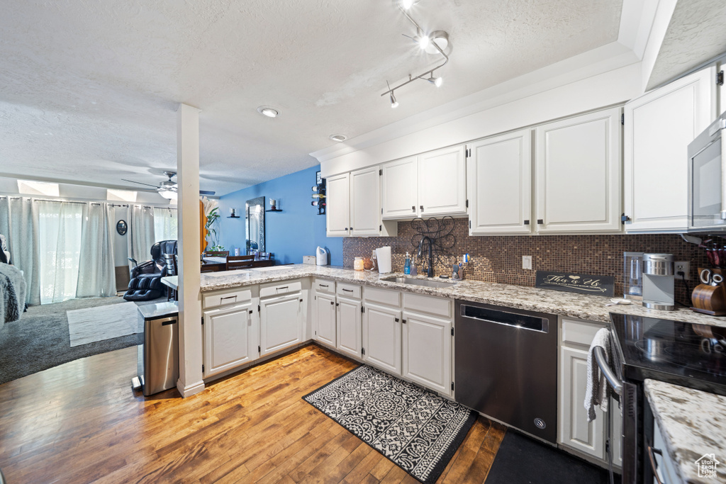 Kitchen featuring appliances with stainless steel finishes, a sink, a textured ceiling, light wood-style floors, and ceiling fan