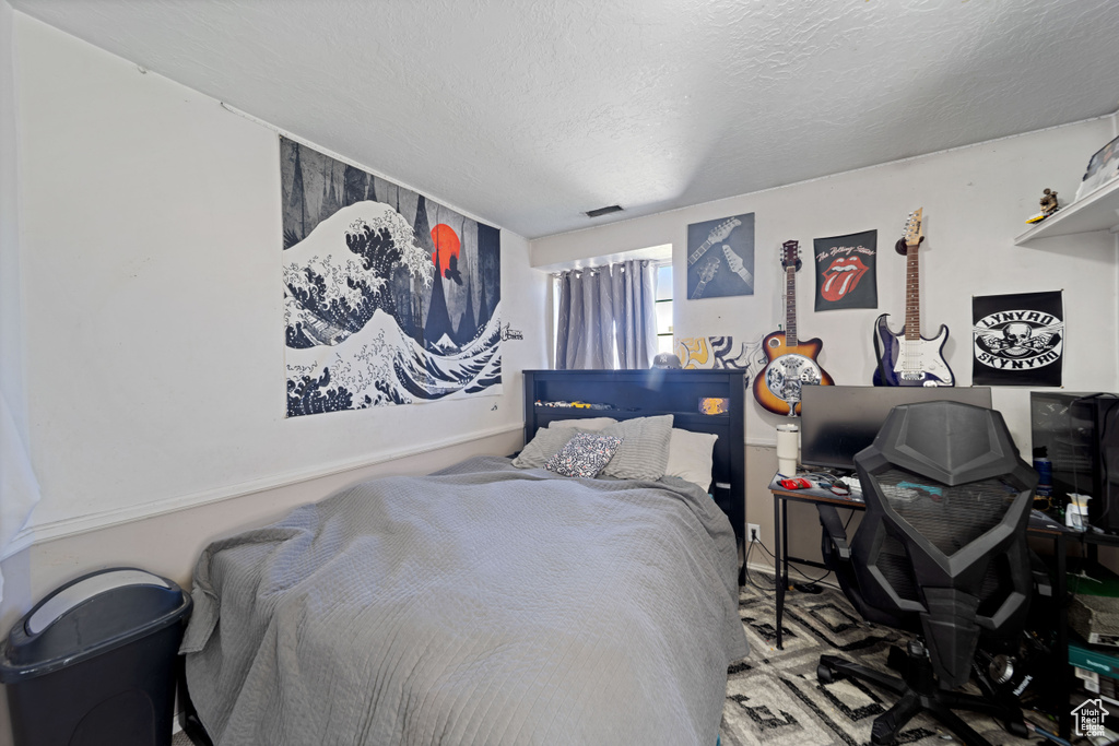 Bedroom featuring a textured ceiling and carpet floors