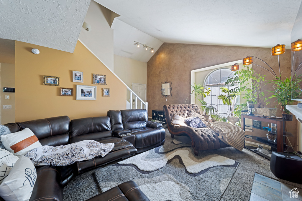 Living room featuring vaulted ceiling and stairs