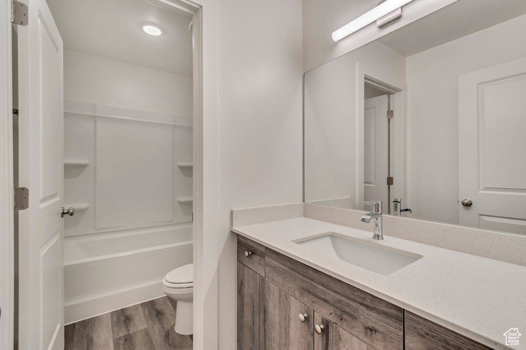 Bathroom with vanity, toilet, and wood finished floors