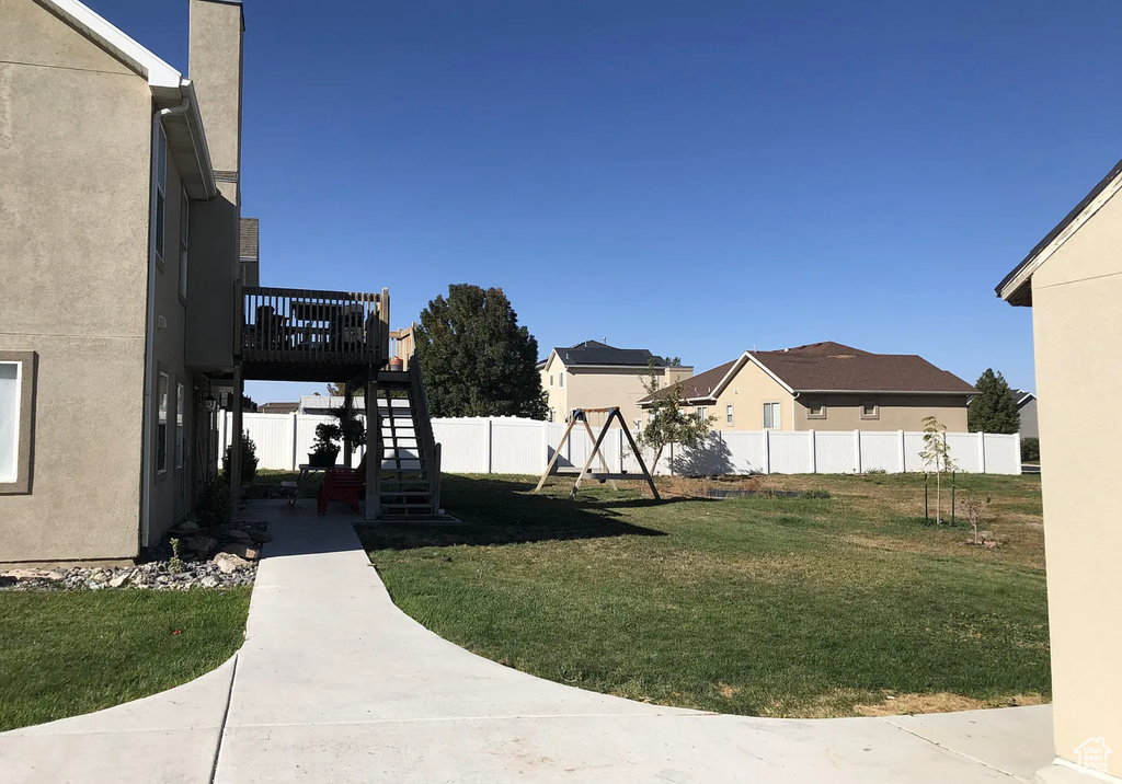 View of yard with a deck, stairway, a patio, and fence