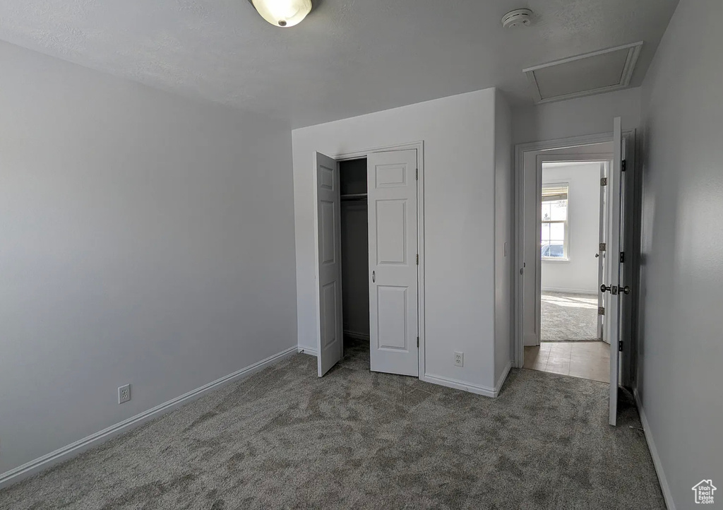 Unfurnished bedroom with a closet, baseboards, and carpet floors