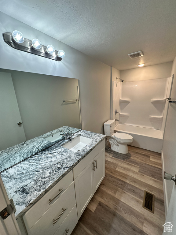 Bathroom featuring toilet, vanity, visible vents, and wood finished floors