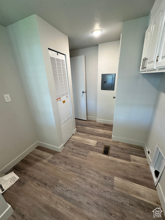 Laundry room with cabinet space, dark wood-type flooring, baseboards, and visible vents