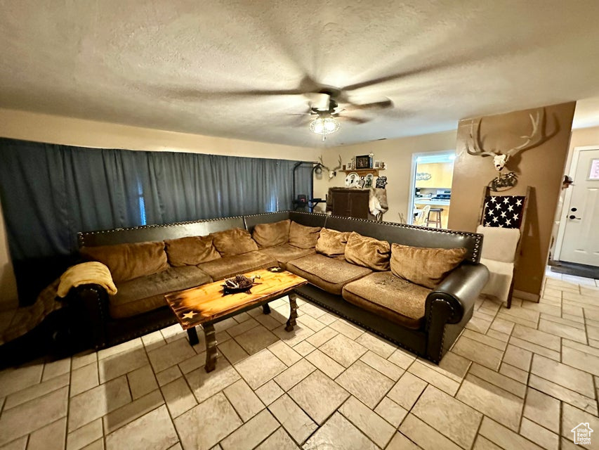 Living room featuring a textured ceiling and a ceiling fan