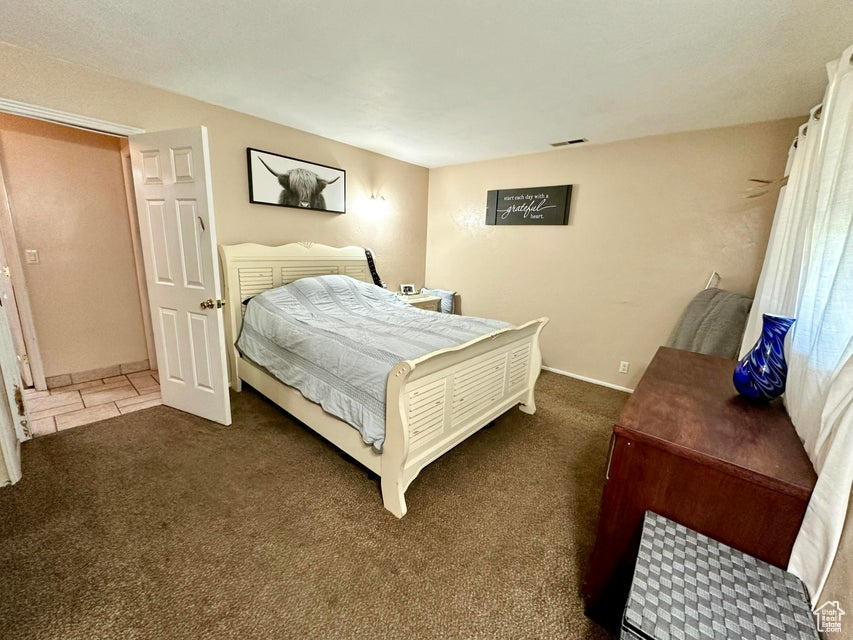 Bedroom with visible vents, baseboards, and carpet floors