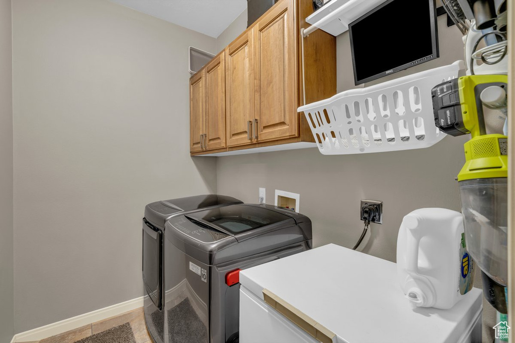 Laundry area featuring cabinet space, separate washer and dryer, and baseboards