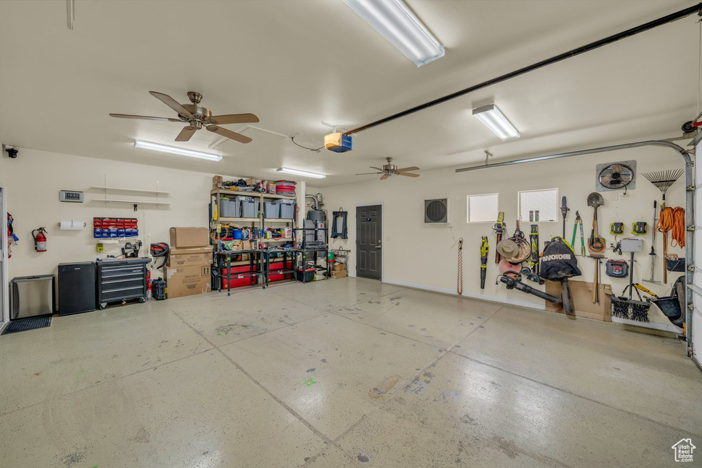 Garage with ceiling fan, a workshop area, and a garage door opener
