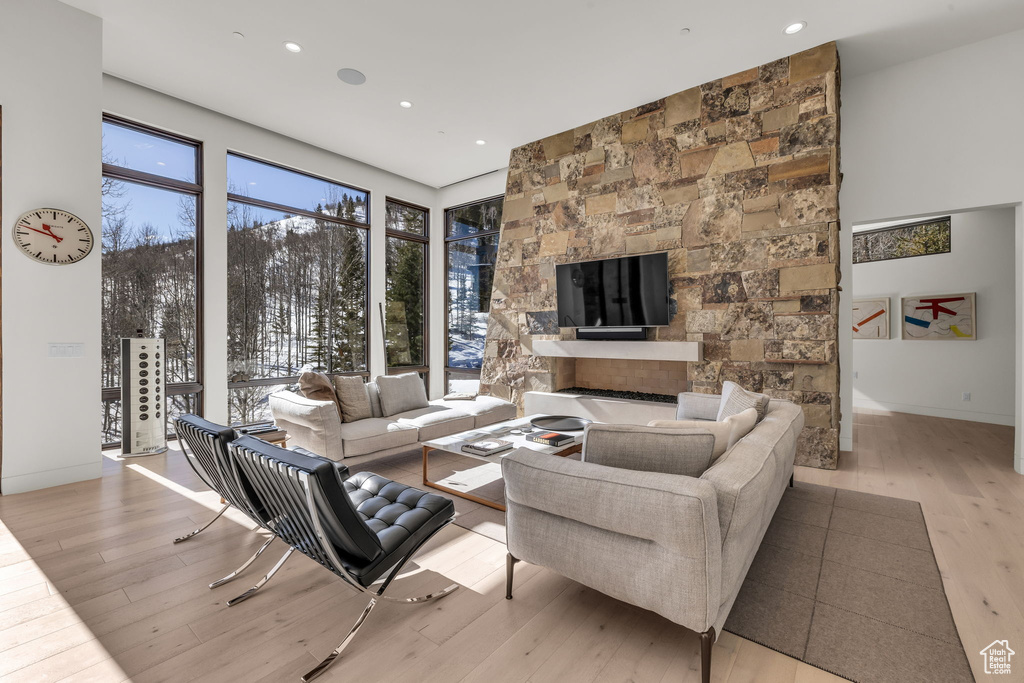 Living room featuring light wood-style floors, a fireplace, and recessed lighting
