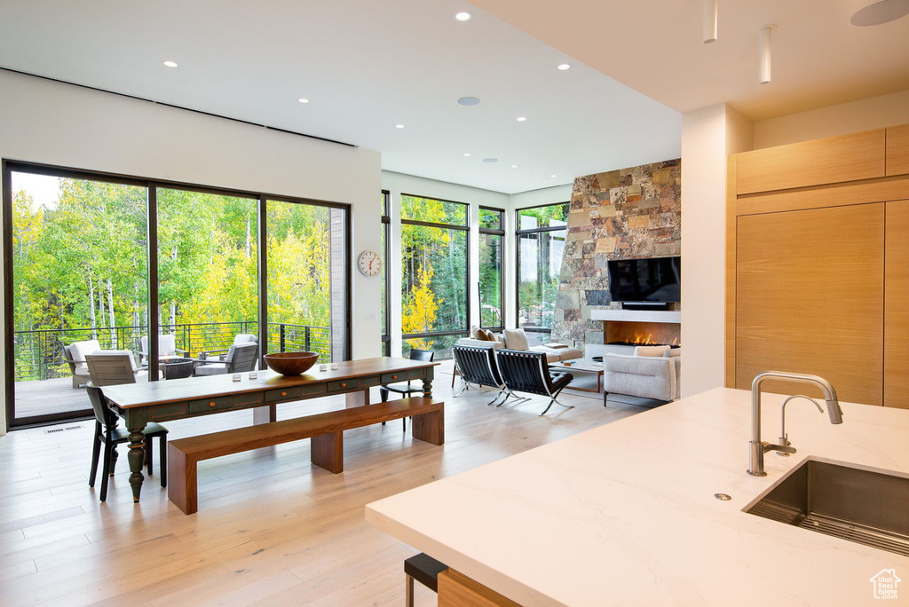Kitchen featuring light wood finished floors, a fireplace, recessed lighting, and a sink