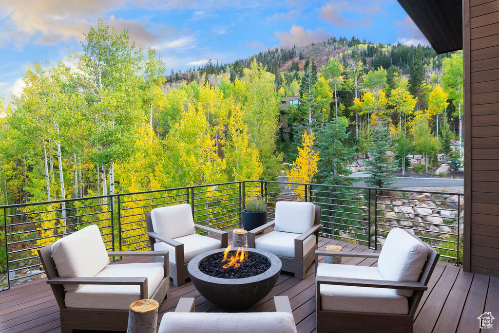Deck with an outdoor living space with a fire pit and a forest view