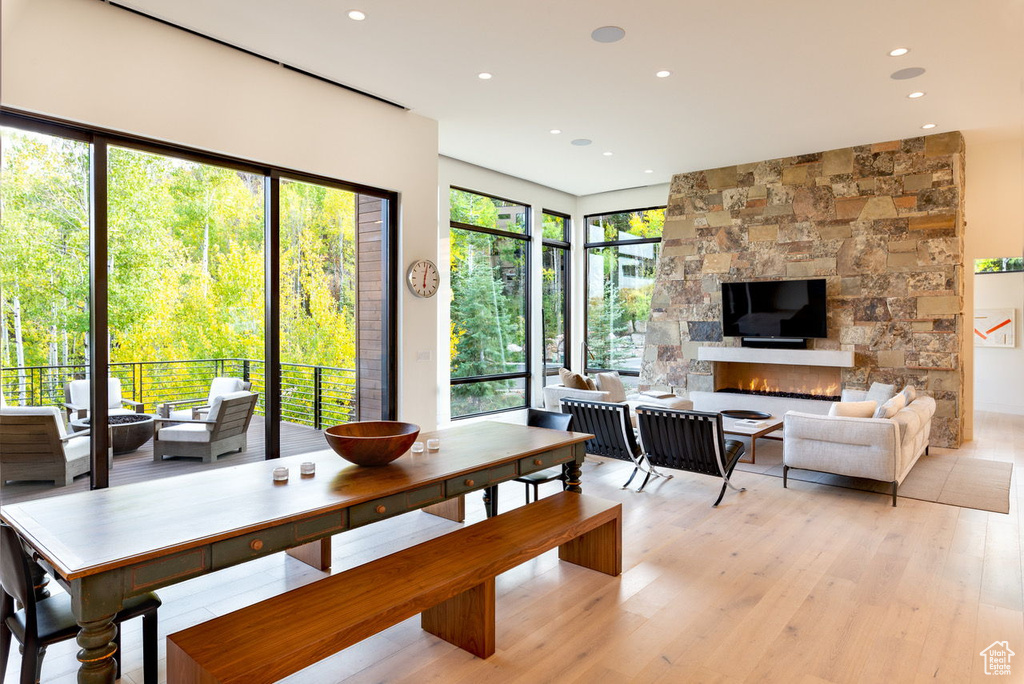 Dining space featuring a stone fireplace, light wood-type flooring, and recessed lighting