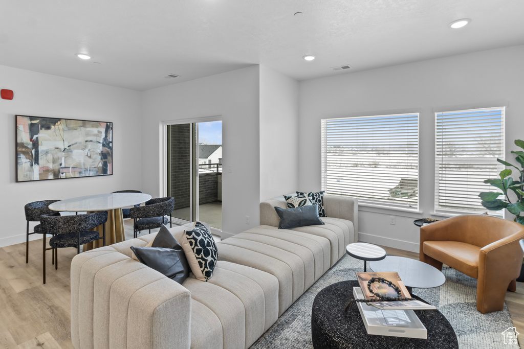 Living area featuring a wealth of natural light, baseboards, visible vents, and light wood-style floors